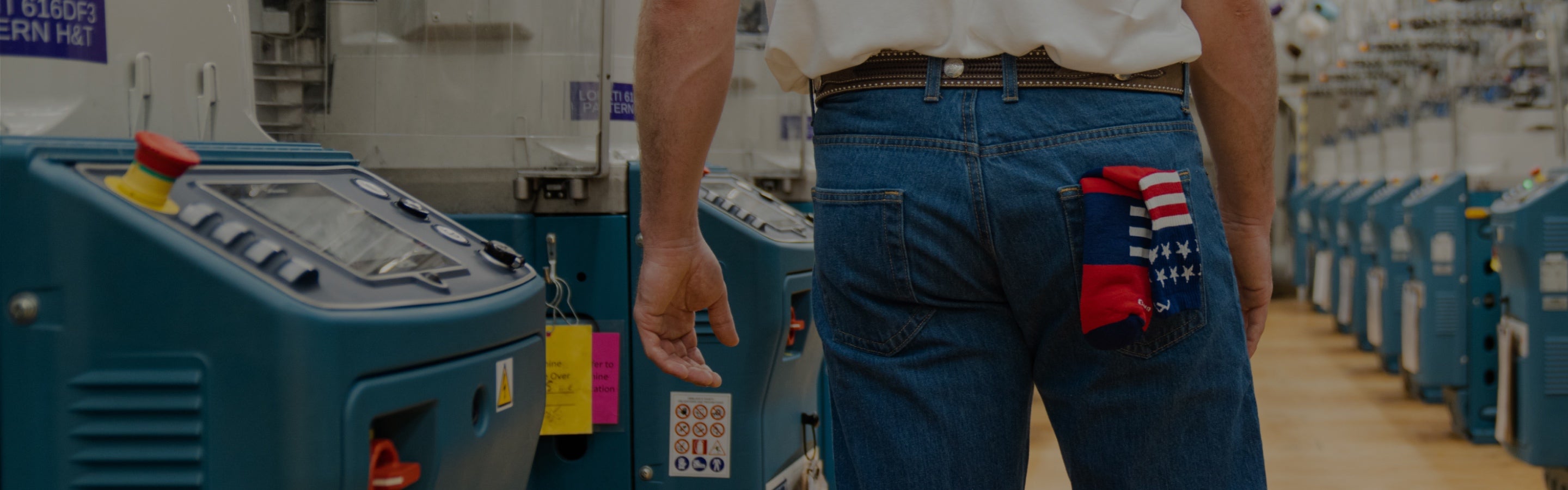 A close-up of someone standing in the Mill showing their back pocket which has a red white and blue sock in it