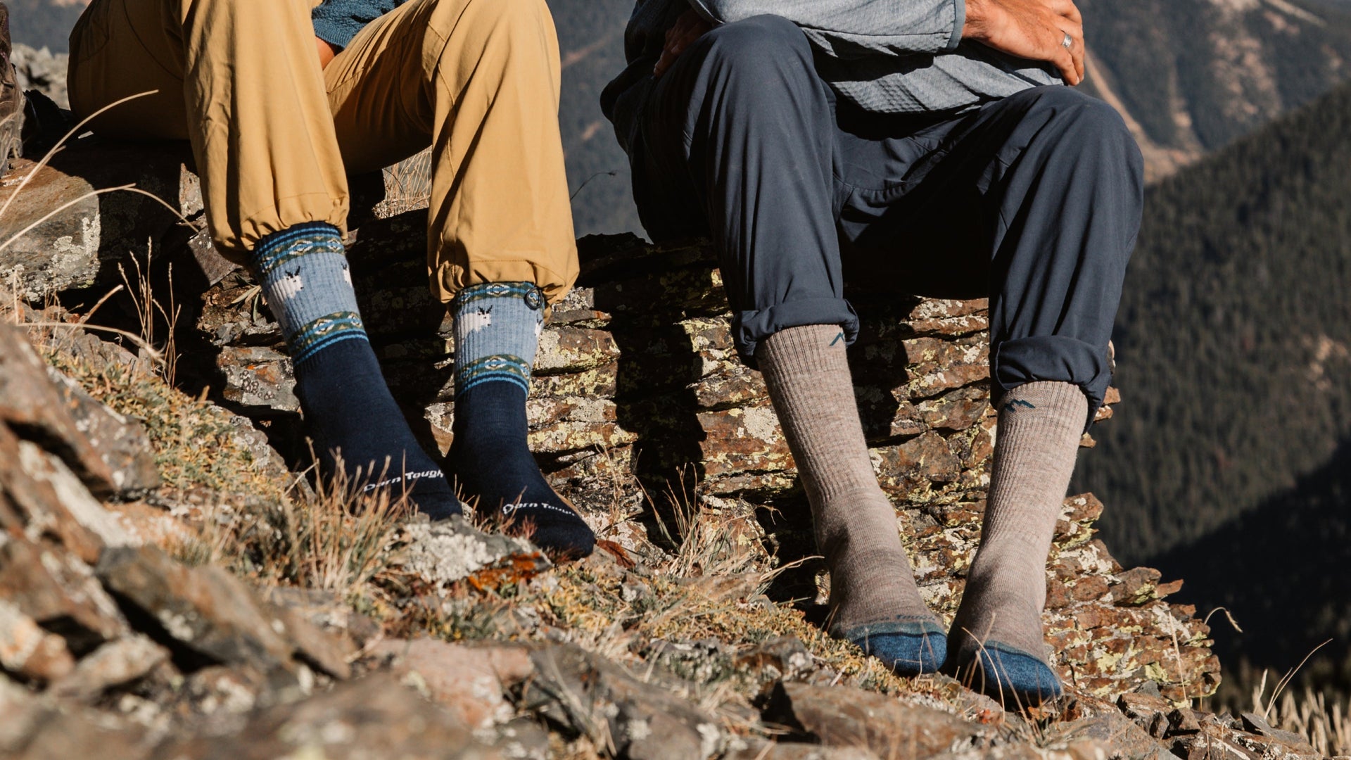 Two models sitting on rock wearing the vanna grizzle and midweight hiker boot in rye
