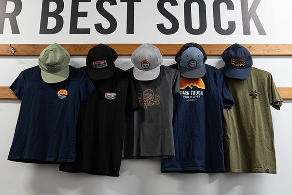 Darn Tough hats and t-shirts with the logo hanging on the wall