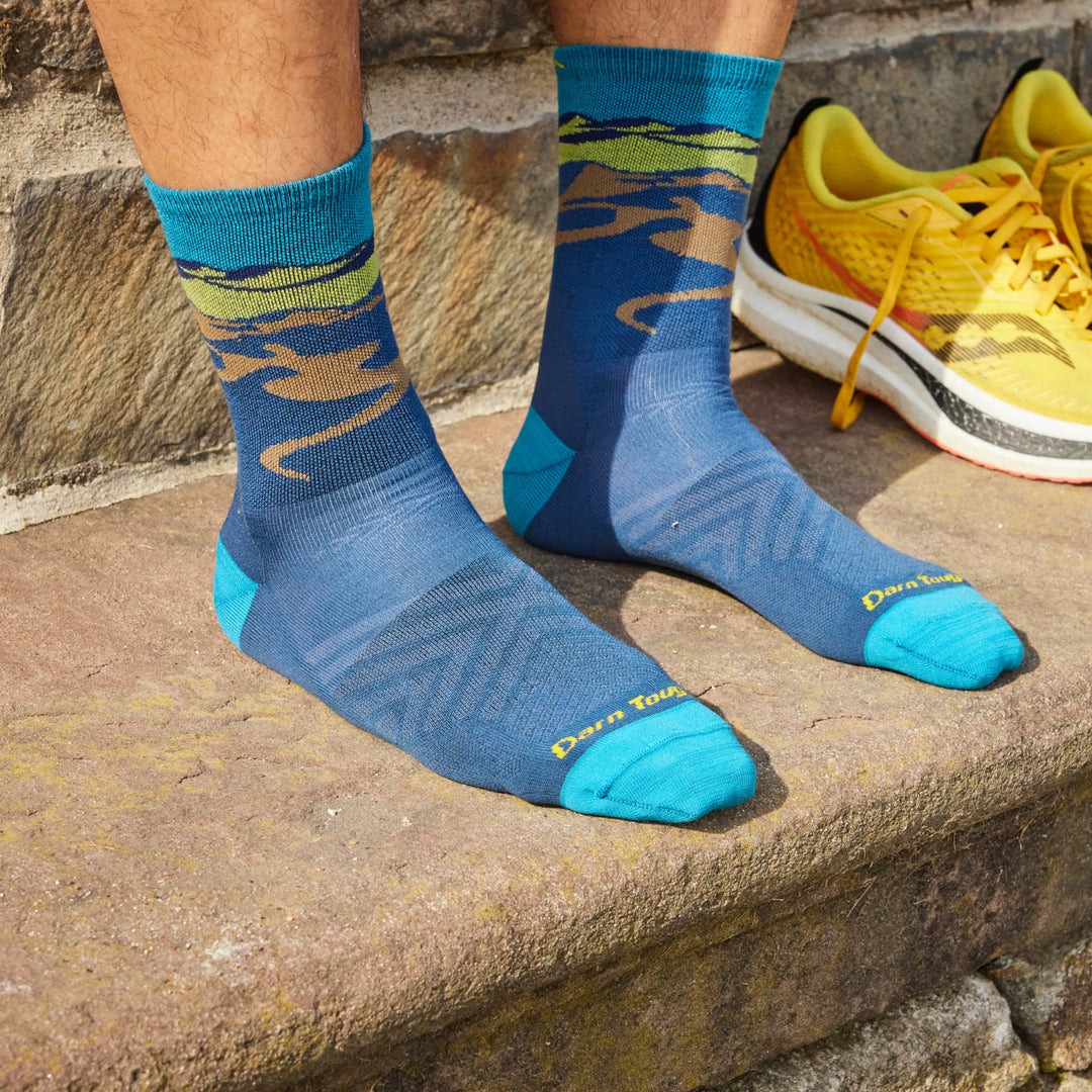 Models feet on stone step wearing the Men's Ridge Runner Micro crew Running sock in Midnight 