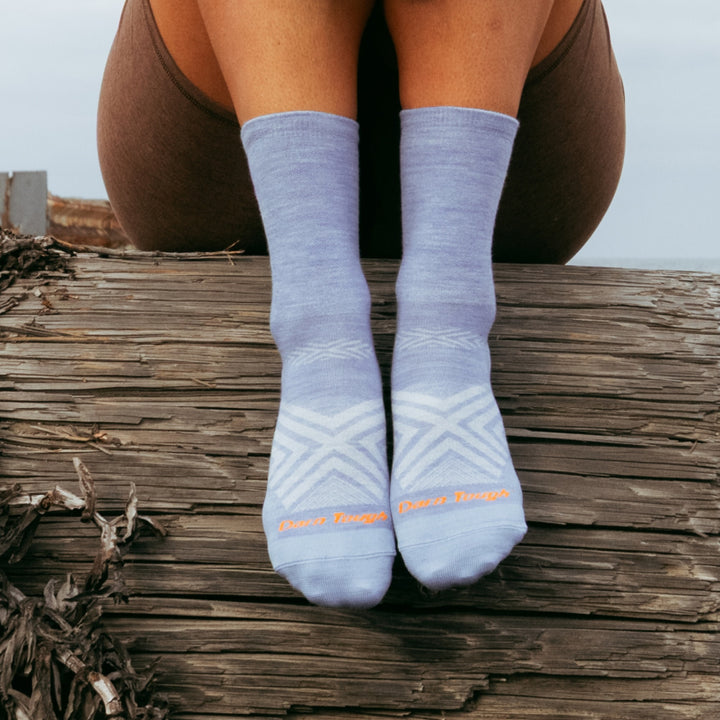models feet hanging over a wood pillar wearing the 1068 micro crew running sock in vapor colorway