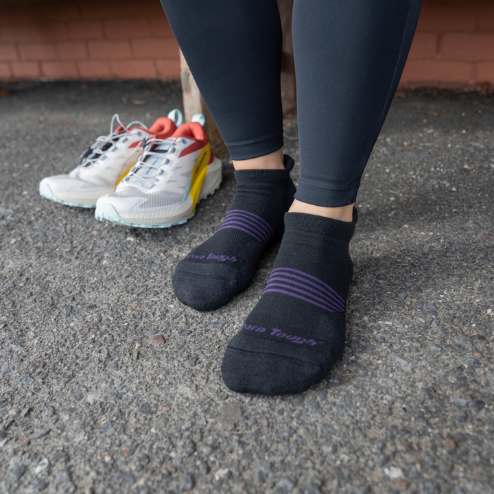 Models feet on concreate wearing the 1112 No show element run sock in black