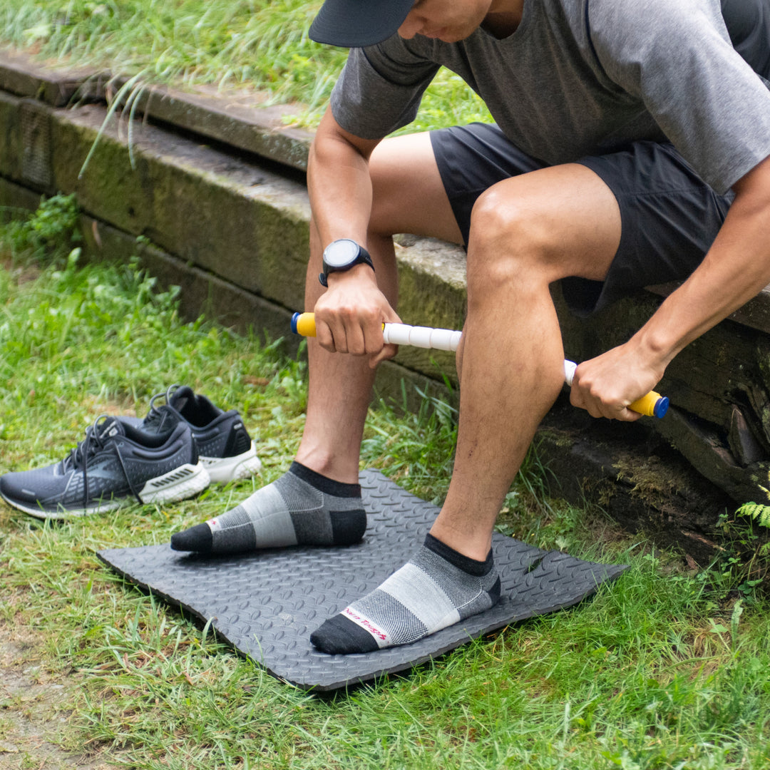 Athlete with feet on mat rolling out legs wearing 1437 athletic socks