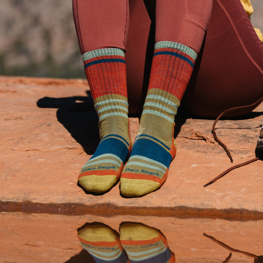 Model wearing 1968 socks in Saandstone colorway without shoes against red desert rocks