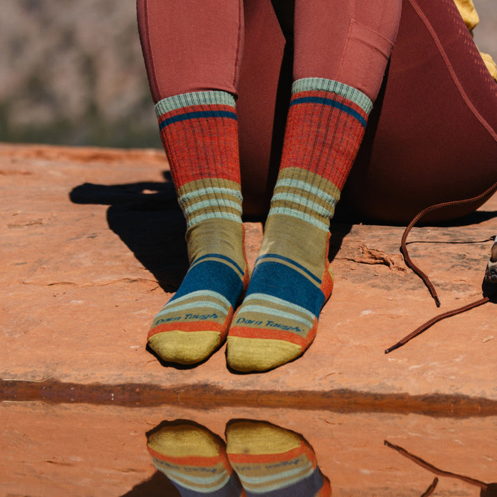 Model wearing 1968 socks in Saandstone colorway without shoes against red desert rocks