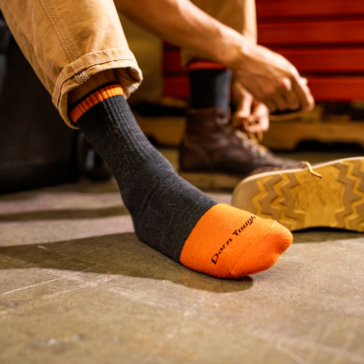 Worker putting on work shoes over steely micro crew work socks
