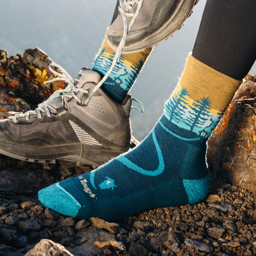 Close up on model of 5013 Northwoods in Dark teal with foot resting on rocks