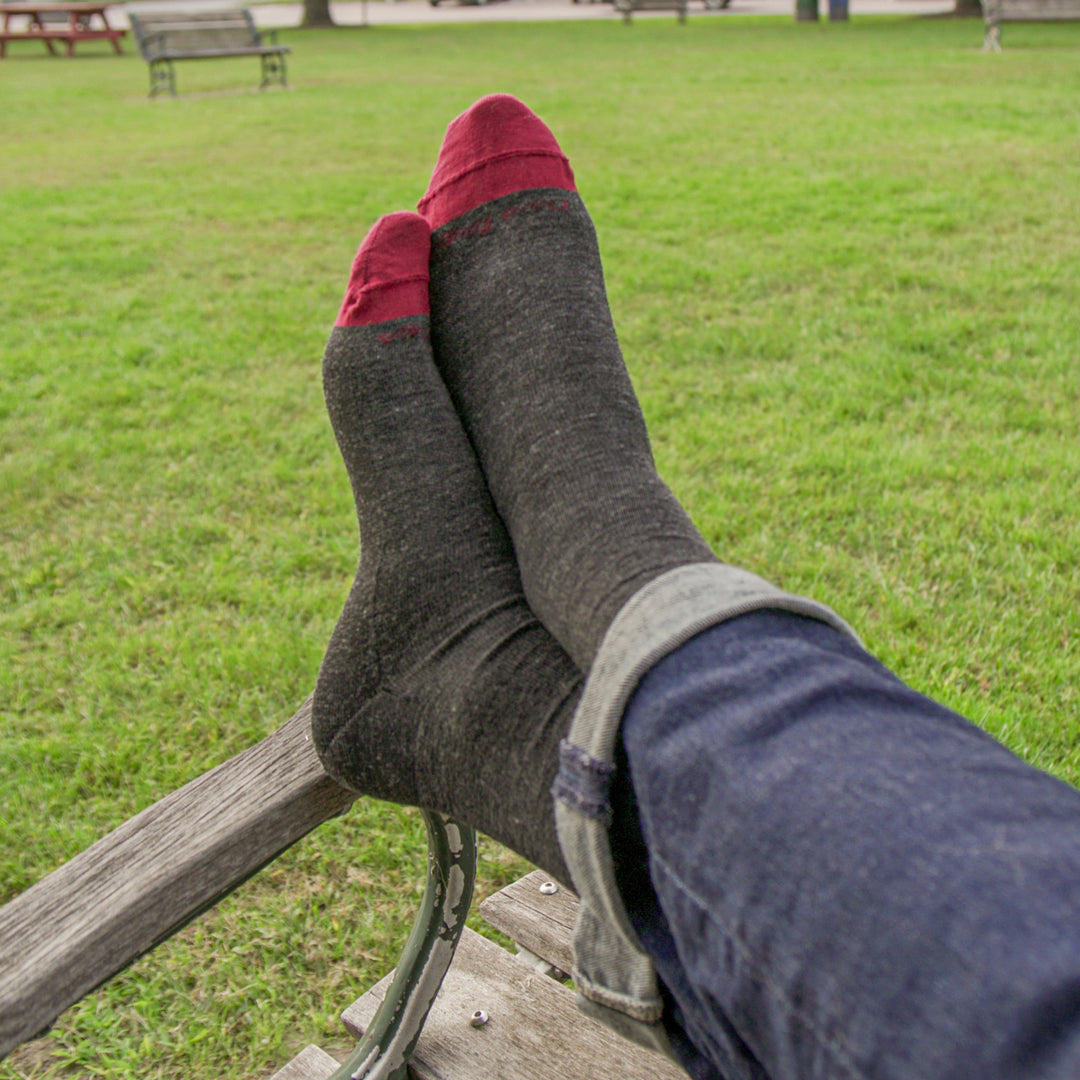 up close on model with feet up on bench wearing the 6032 Solid crew in charcoal featuring red toe and charcoal body