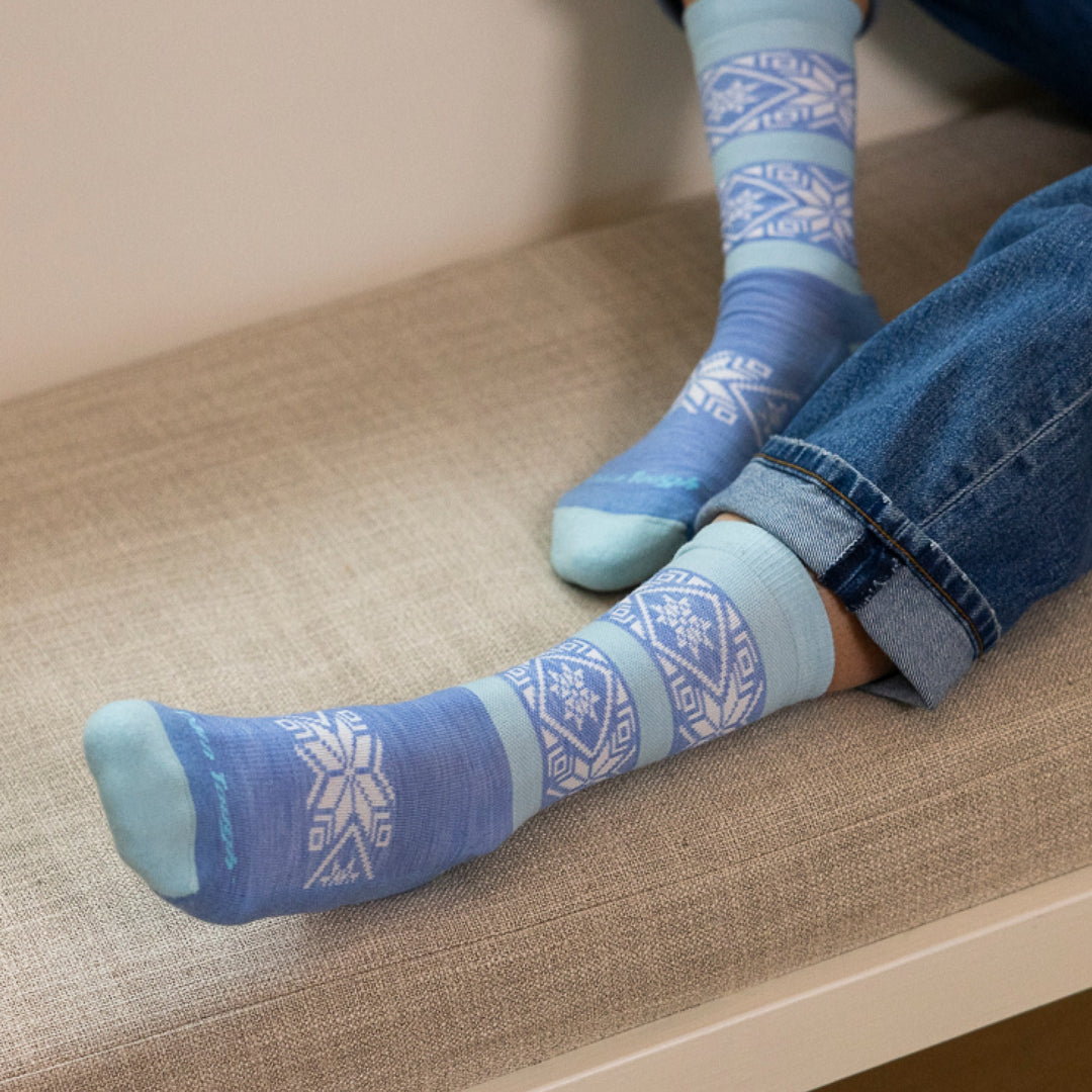 close up image of models feet on couch cushion wearing 6129 elsa crew lightweight with cushion vapor blue sock