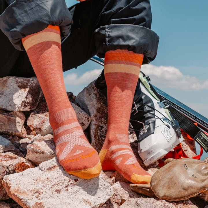 close up on model image of the 8028 canyon resting on rocks next to ski boots and skis