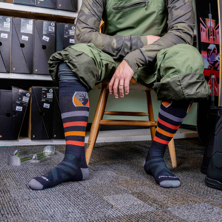 close up on model sitting in chair wearing the 8045 Thermo;ie beer badge in black
