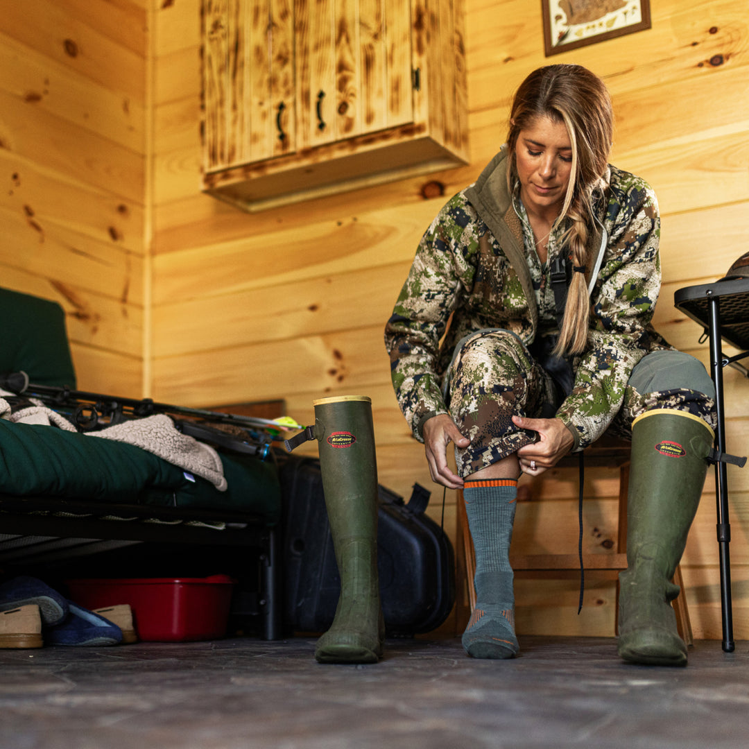 model sitting in chair putting on the 2106 seafoam 