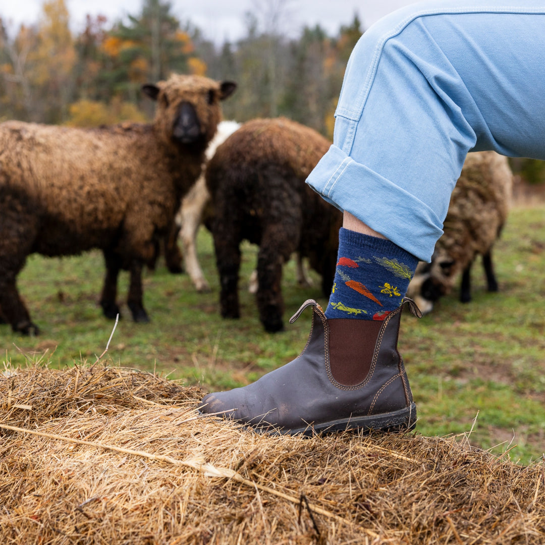 image of model leg on hay bale wearing 6054 farmers market crew lightweight indigo with sheep in background