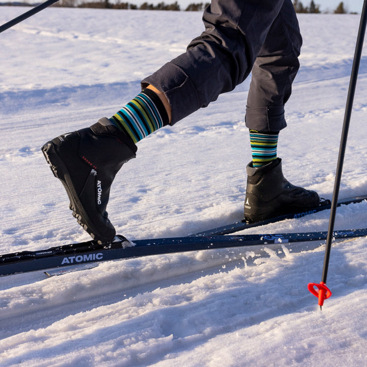 close up of models legs while nordic skiing wearing 8034 oslo nordic boot lightweight with cushion sock in black with black nordic ski boots