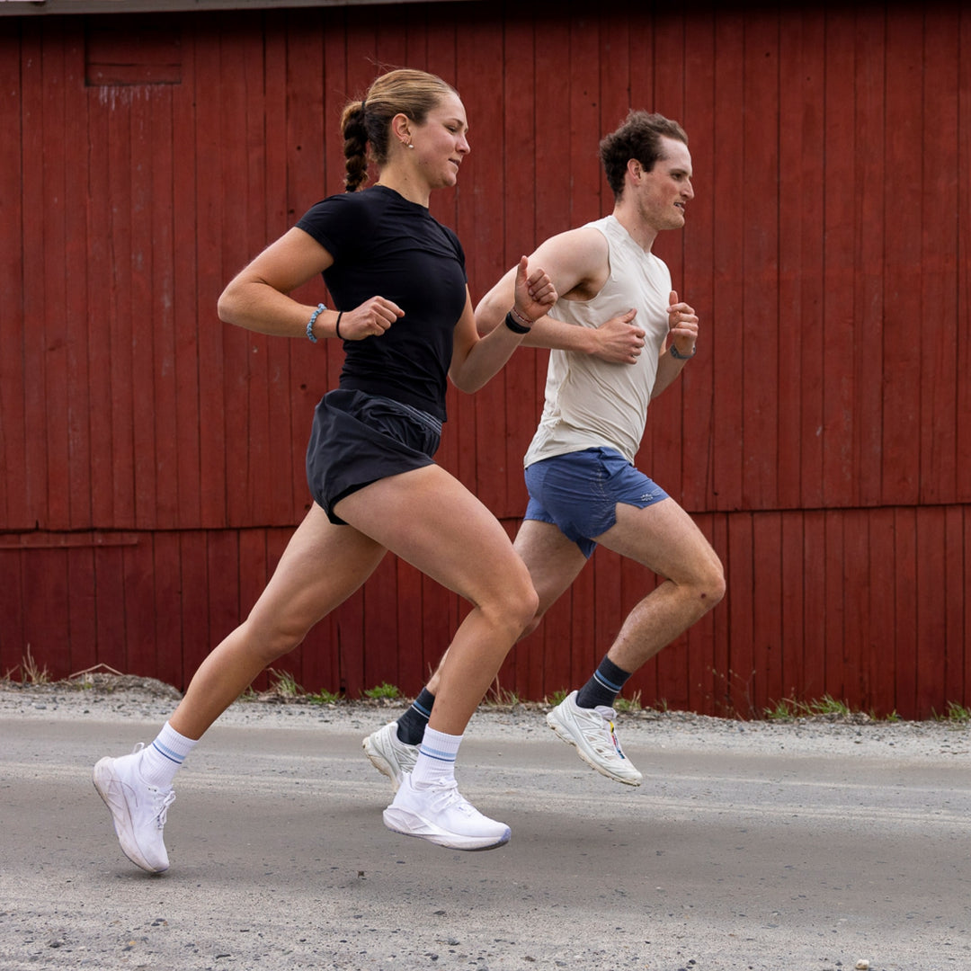 man and woman running in front of red barn man wearing 1118 element micro crew light weight with cushion gray sock