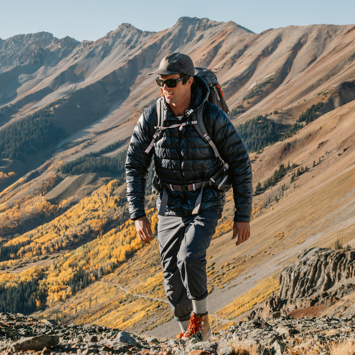 model hiking up canyon mountain side wearing the 1953 micro crew mountaineering sock in geyser