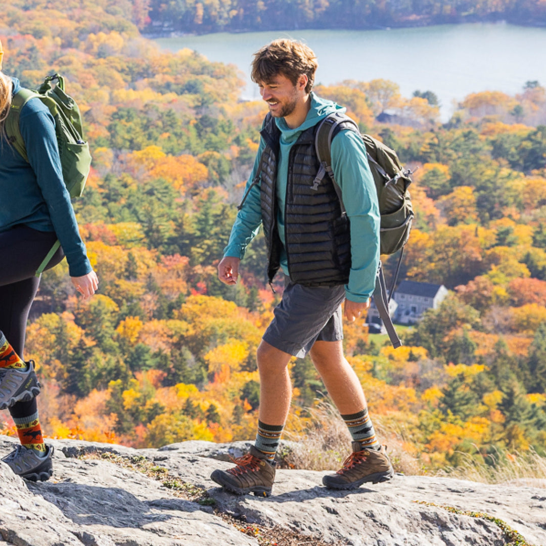 man hiking with foliage in background wearing hiking boots with 1980 boot midweight with cushion trout river sock