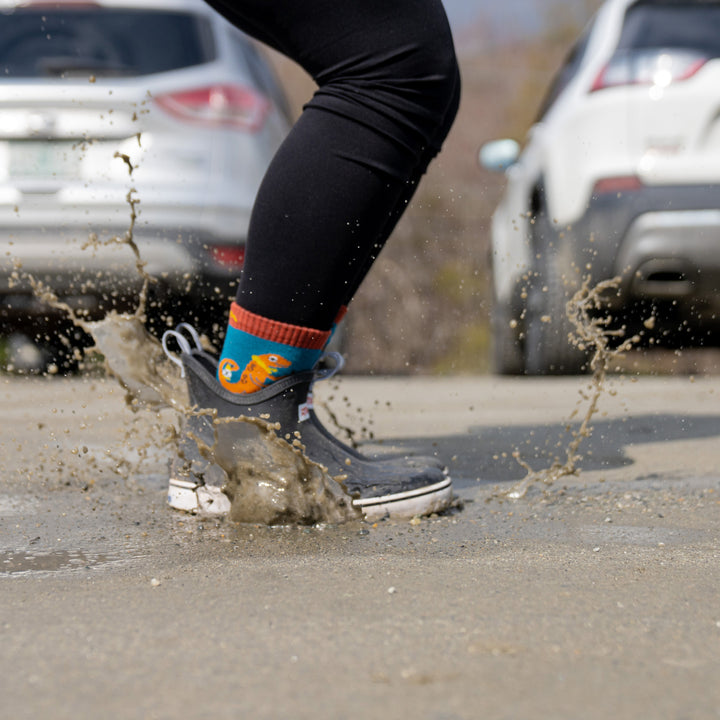 Model wearing 3043 socks in lava and rubber ankle boots splashing in puddle