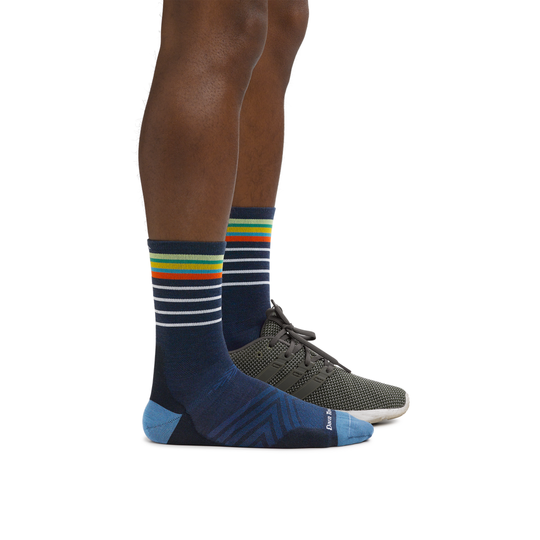 Man wearing Stride Micro Crew Ultra-Lightweight Running Socks in Eclipse with a running shoe on the foot in back