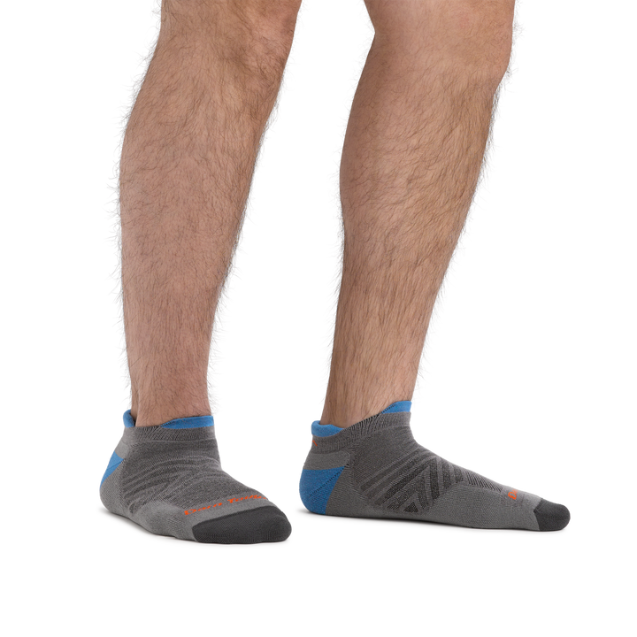 Studio photo of model wearing men's coolmax run no show running socks in gray.