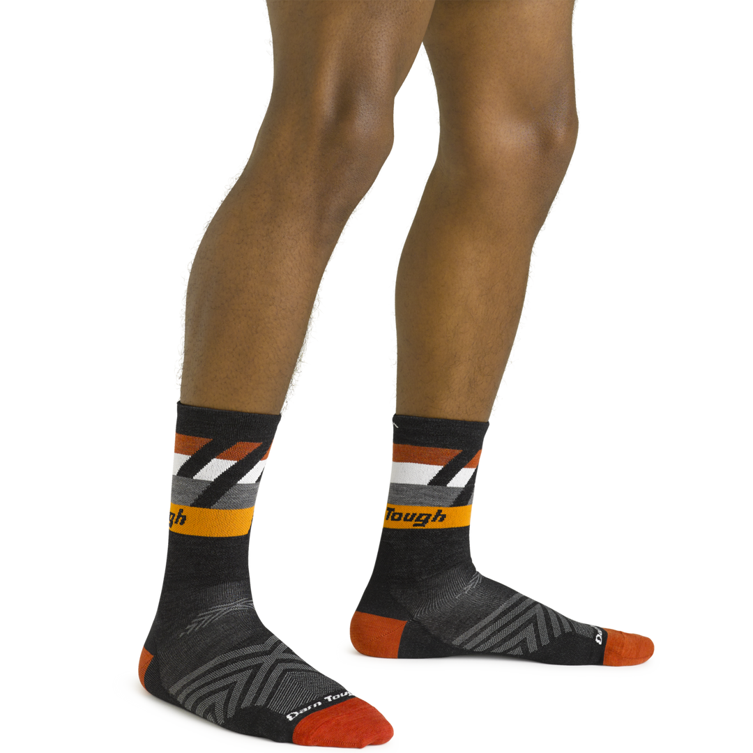 Close up shot of model wearing the men's grit micro crew running socks in black with no shoes on