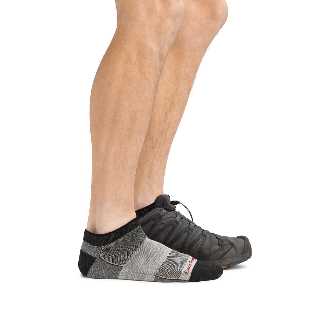 Profile of male legs wearing  1437 No Show Athletic Sock in charcoal and back foot wearing a sneaker