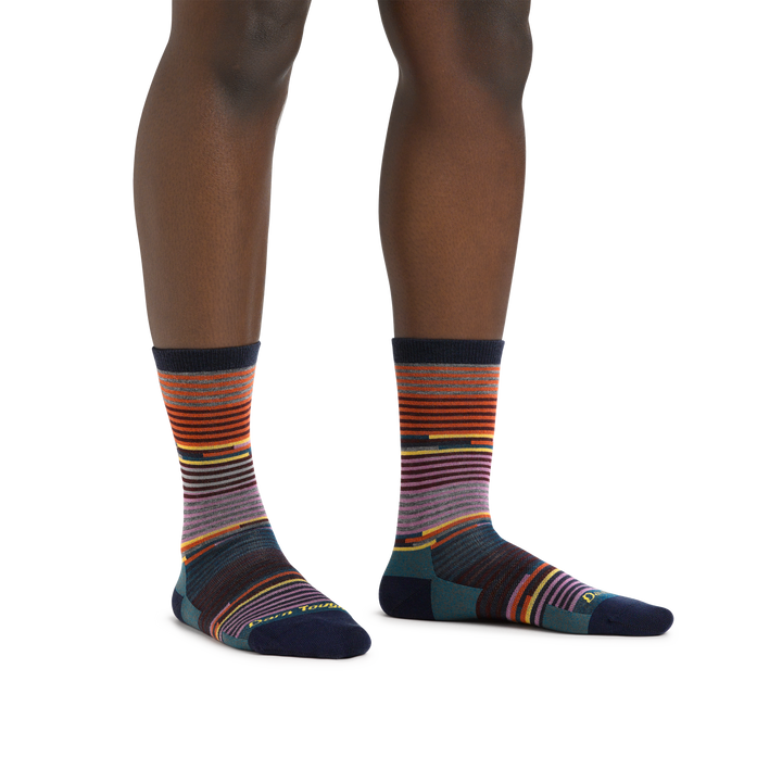 Image of a woman's legs, standing on a white background wearing Women's Pixie Crew Lightweight Lifestyle Socks in Navy