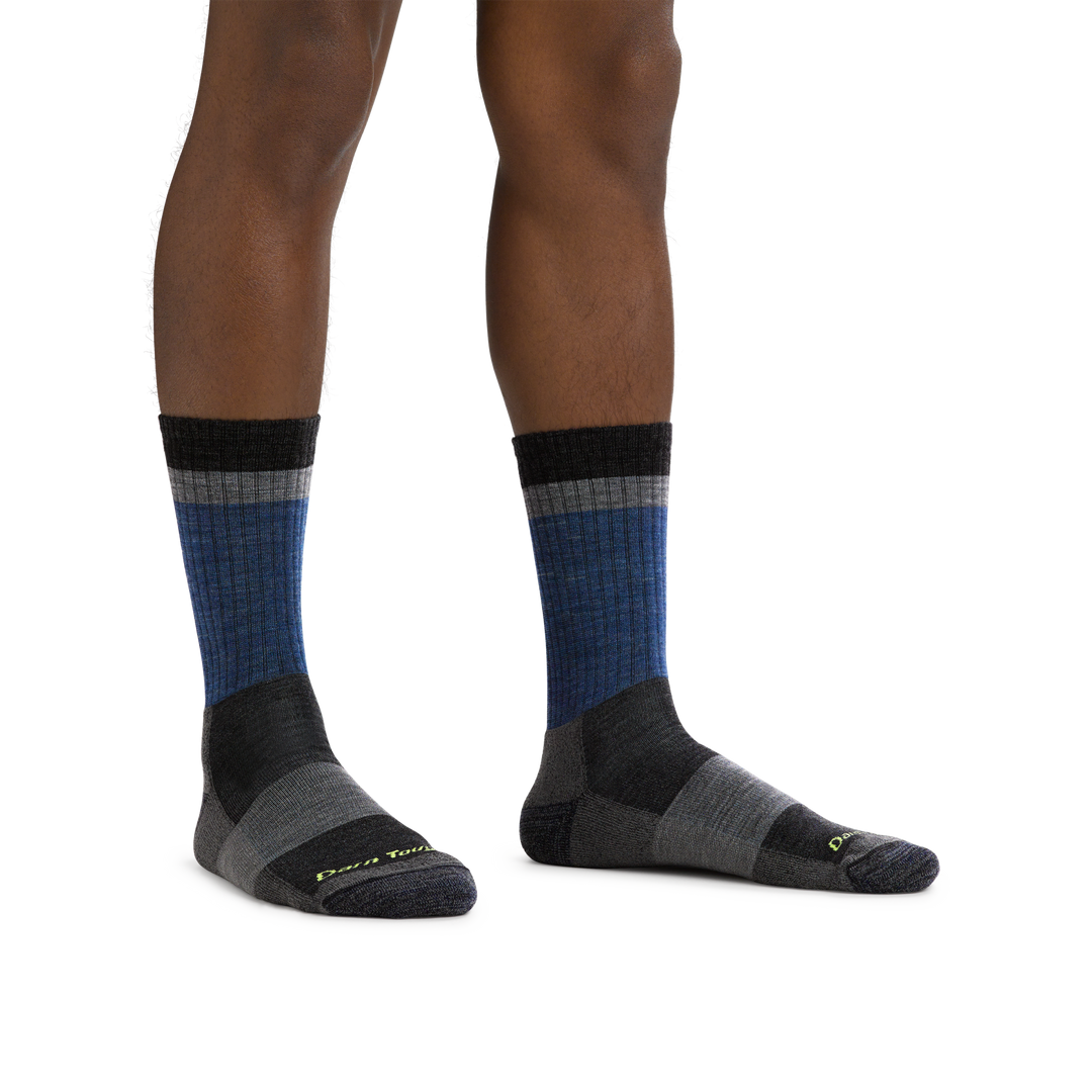 Man barefoot, wearing Heady Stripe Micro Crew Hiking socks in Blue