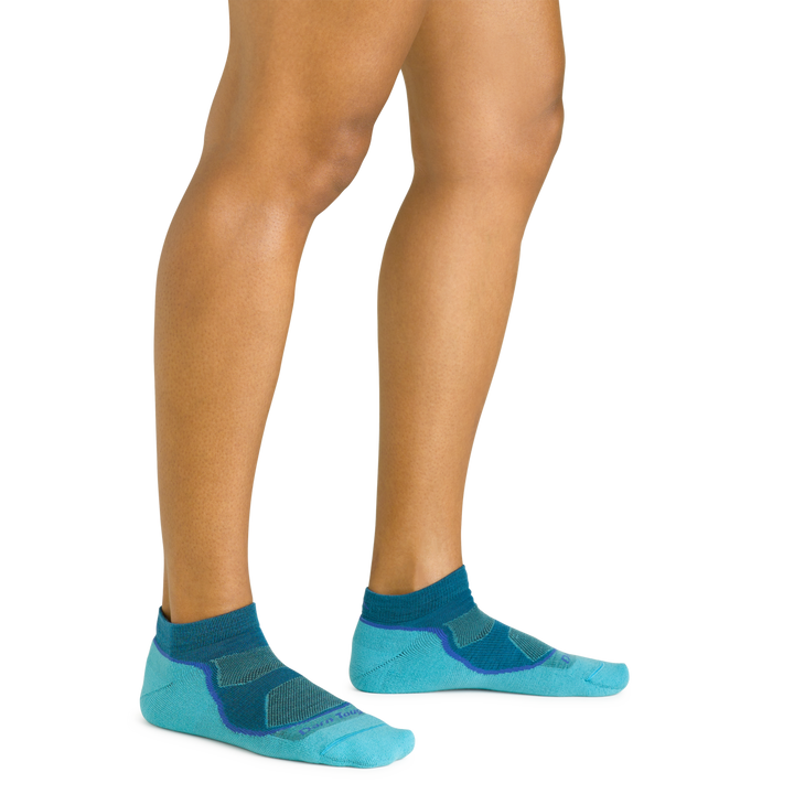 Close up shot of model wearing the women's light hiker no show hiking sock in cascade blue with no shoes on