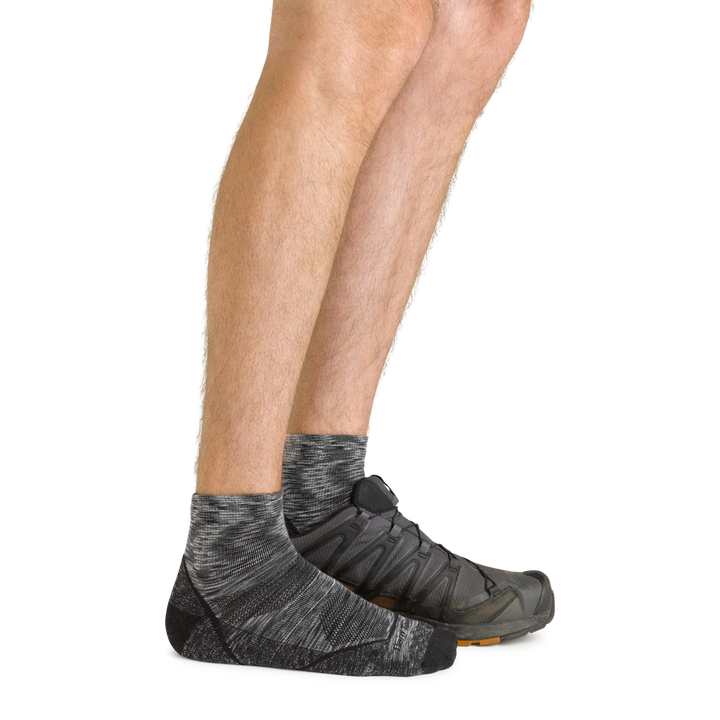 Side shot of model wearing the men's light hiker quarter hiking sock in space gray with a gray shoe on his left foot