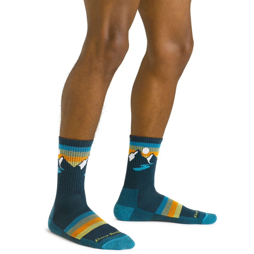 Close up shot of model wearing the men's sunset ridge micro crew hiking sock in bottle blue with no shoes on