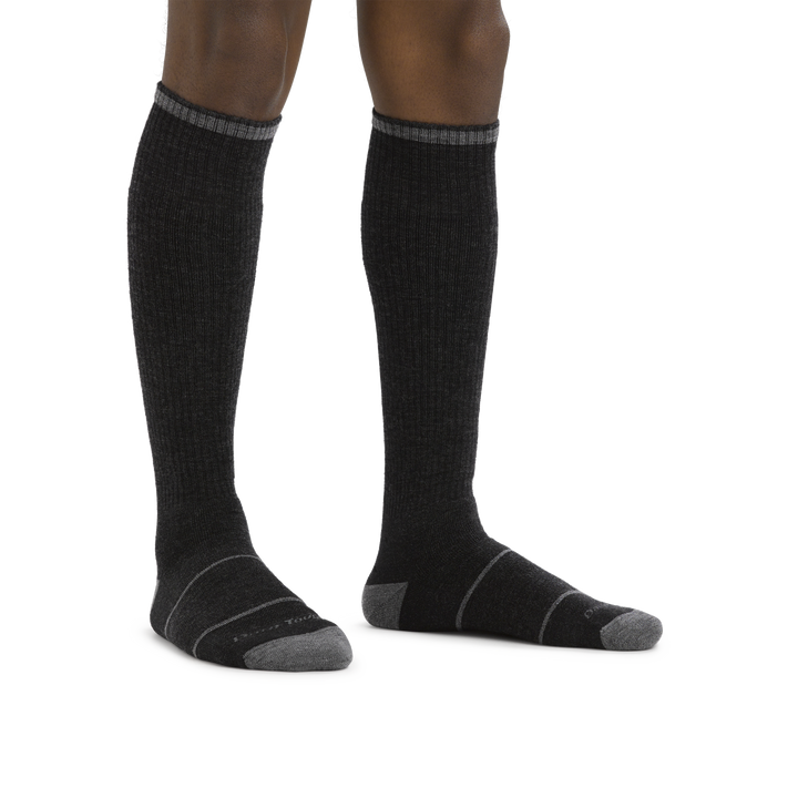Man standing barefoot wearing Paul Bunyan Over the Calf Midweight Work Sock in Gravel