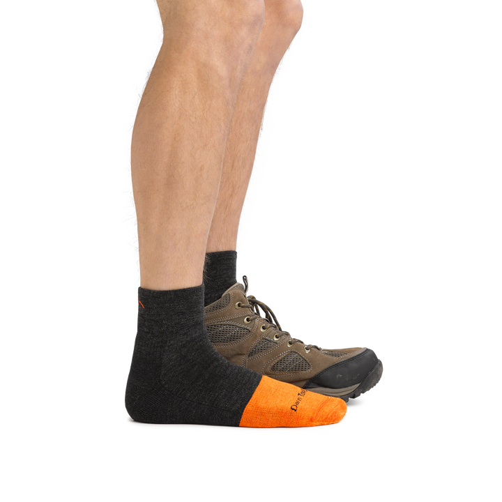 Man facing to the right wearing Steely Quarter Midweight Work Sock in Graphite and back foot also wearing a hiking boot