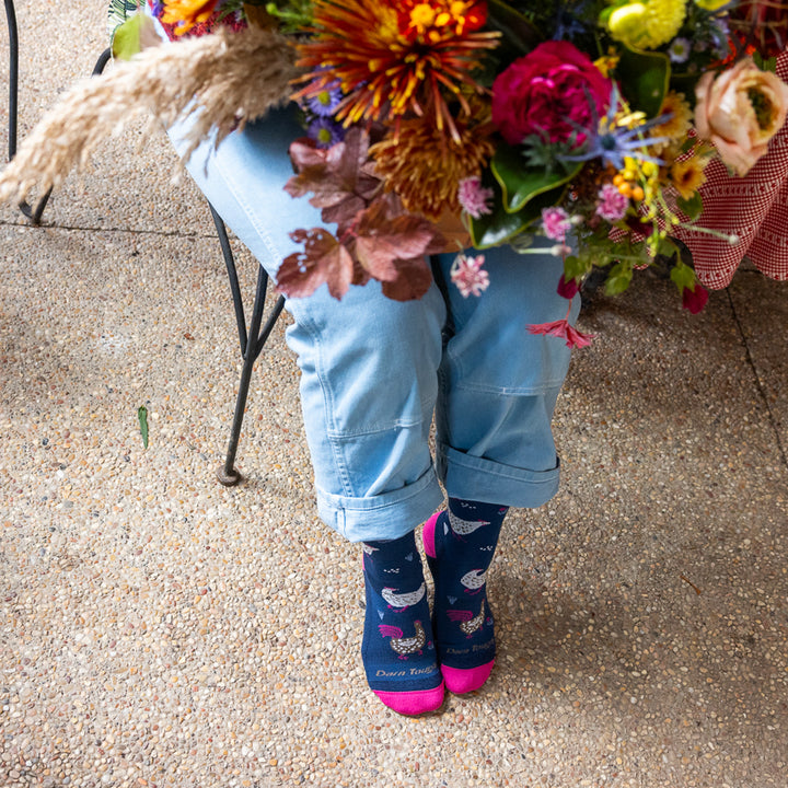 model sitting in chair holding flowers and wearing the 6144 mother clucker in limited edition colorway Midnight