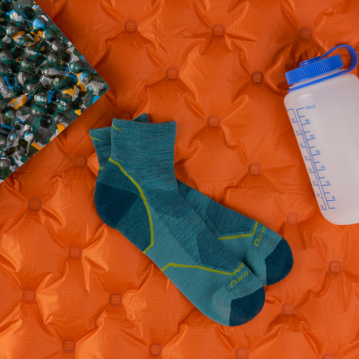 men's lightweight quarter hiker in aqua on an orange sleeping bag with waterbottle 