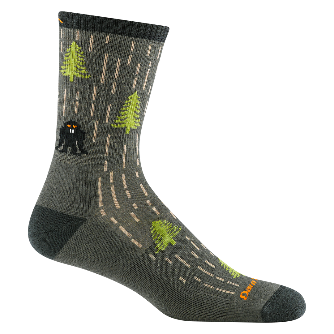 5015 Yarn goblin in forest featuring dark green heel/toe/cuff lighter green body  with bright green trees and a black goblin