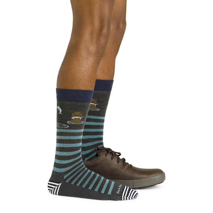Side shot of model wearing the men's animal haus crew lifestyle sock in forest with a brown shoe on his left foot