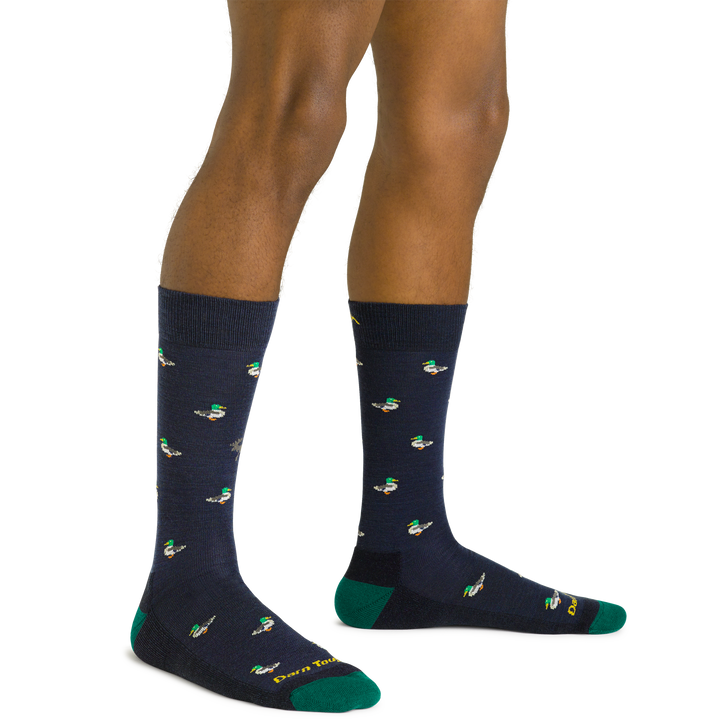 Side studio shot of model wearing men's duck duck moose crew lifestyle sock in navy eclipse