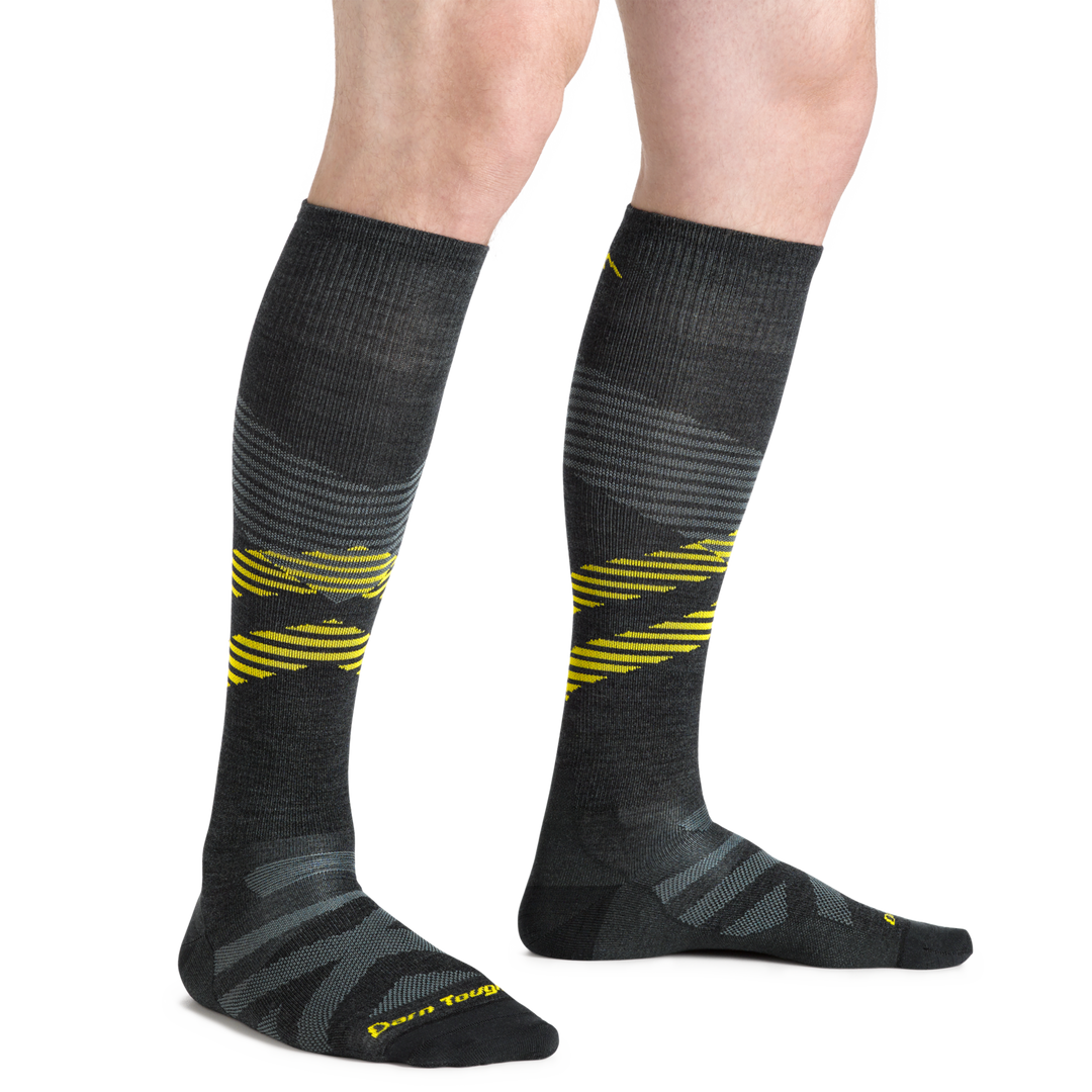Close up studio shot of model wearing men's pennant RFL over-the-calf ultra-light ski & snowboard sock in carbon