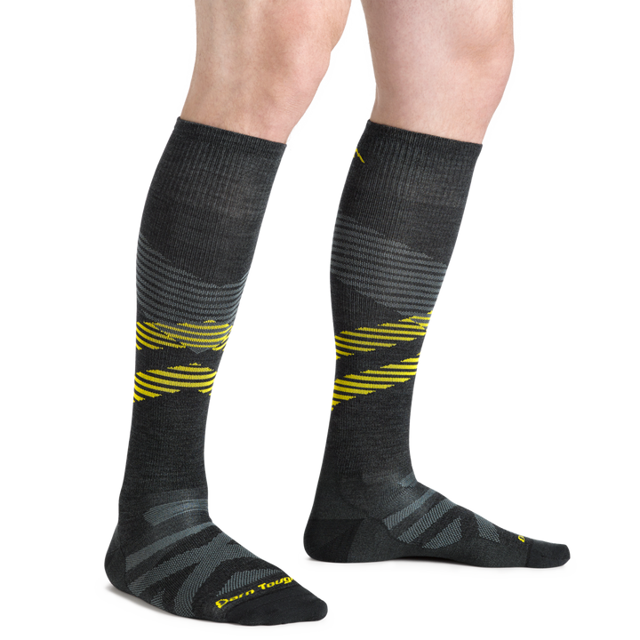 Close up studio shot of model wearing men's pennant RFL over-the-calf ultra-light ski & snowboard sock in carbon