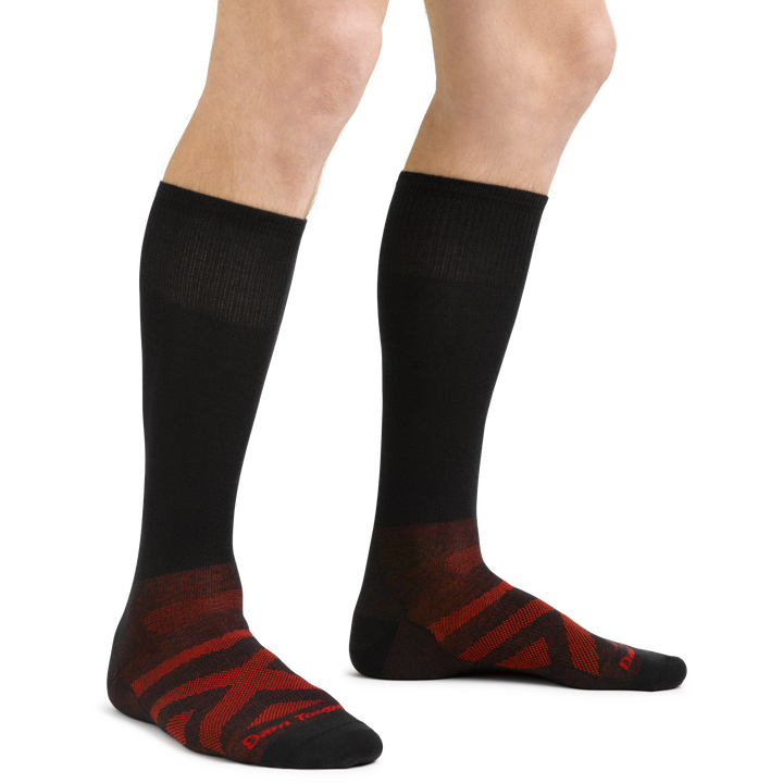 Side studio shot of model wearing the men's thermolite over-the-calf ski & snowboard sock in black