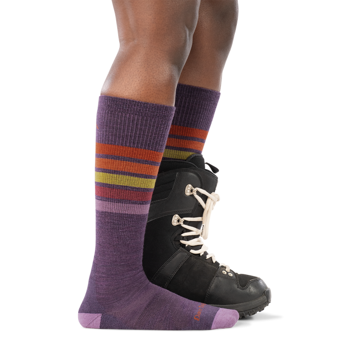 model wearing snowboard boot on back foot and 8048 OTC ski sock in plum side profile