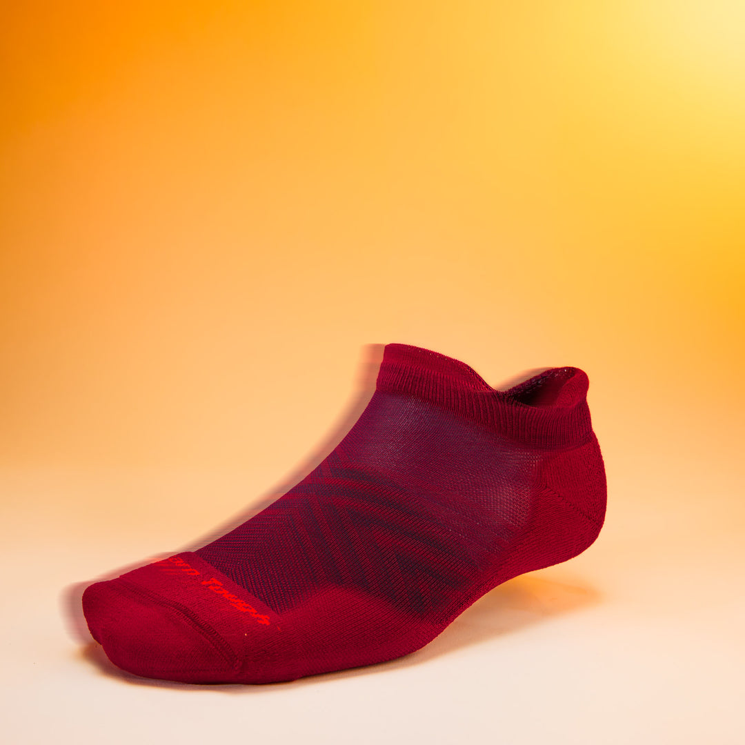 studio shot of mens 1039 Run No Show Tab Ultra-Lightweight with Cushion garnet with orange background