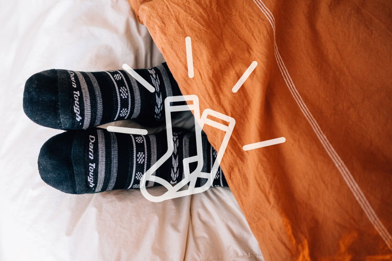Feet in bed in casual socks with a comfort symbol, because these are the most comfortable socks