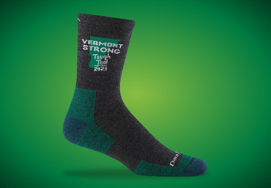 Darn Tough's Vermont Strong sock supporting flood relief. Gray sock with green accents