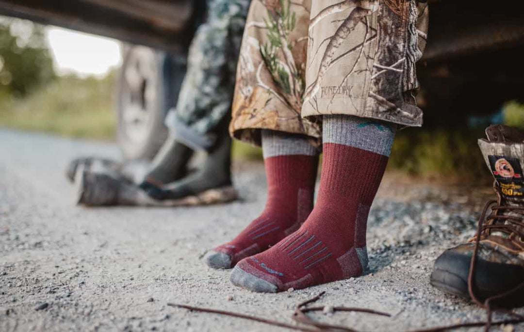 Two hunters getting ready to put boots on over heavyweight hunting socks for cold weather