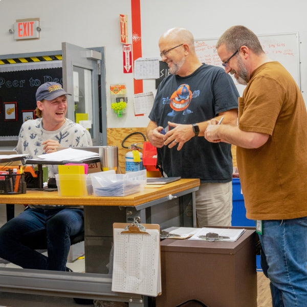 Three Darn Tough employees laughing at a joke as they collaborate 