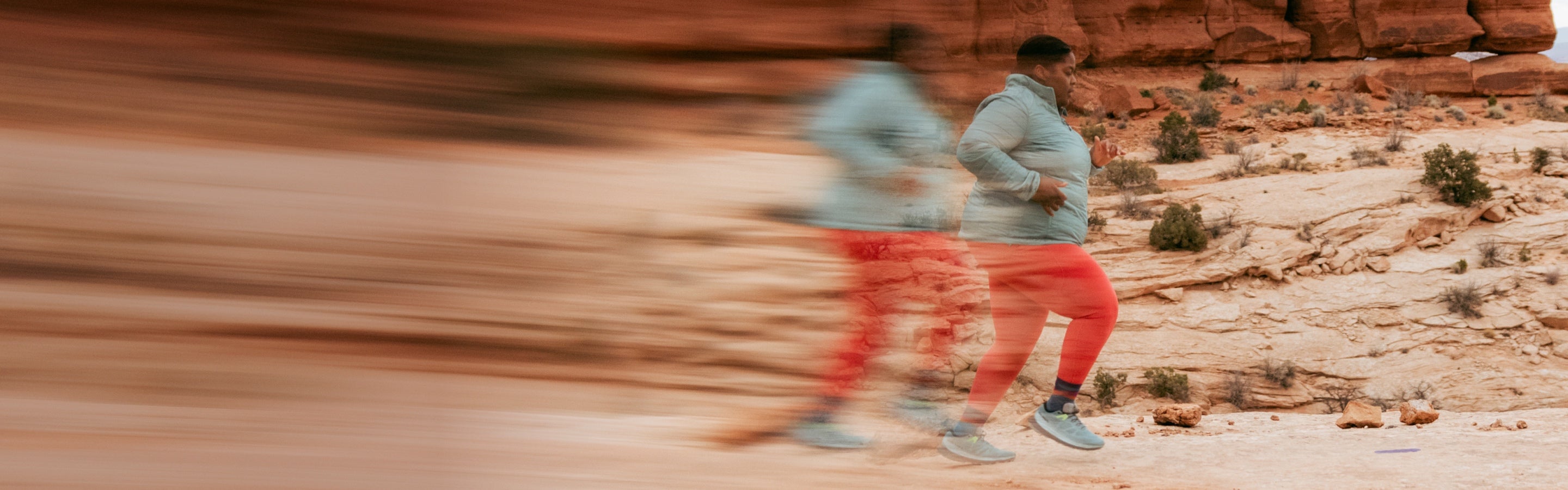 Runner Mirna Valerio wearing Darn Tough socks running out west through a canyon