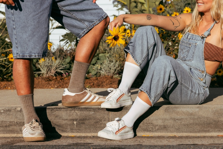 A couple seated on steps wearing solid white and brown Darn Tough socks
