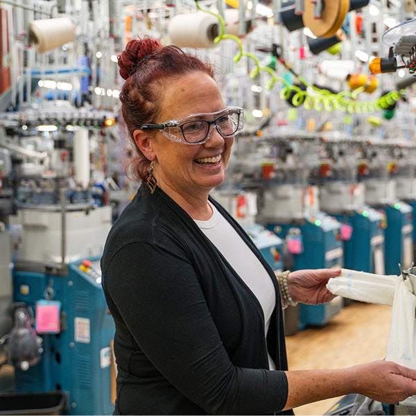 Bridget laughing as she inspects a sock in the Mill